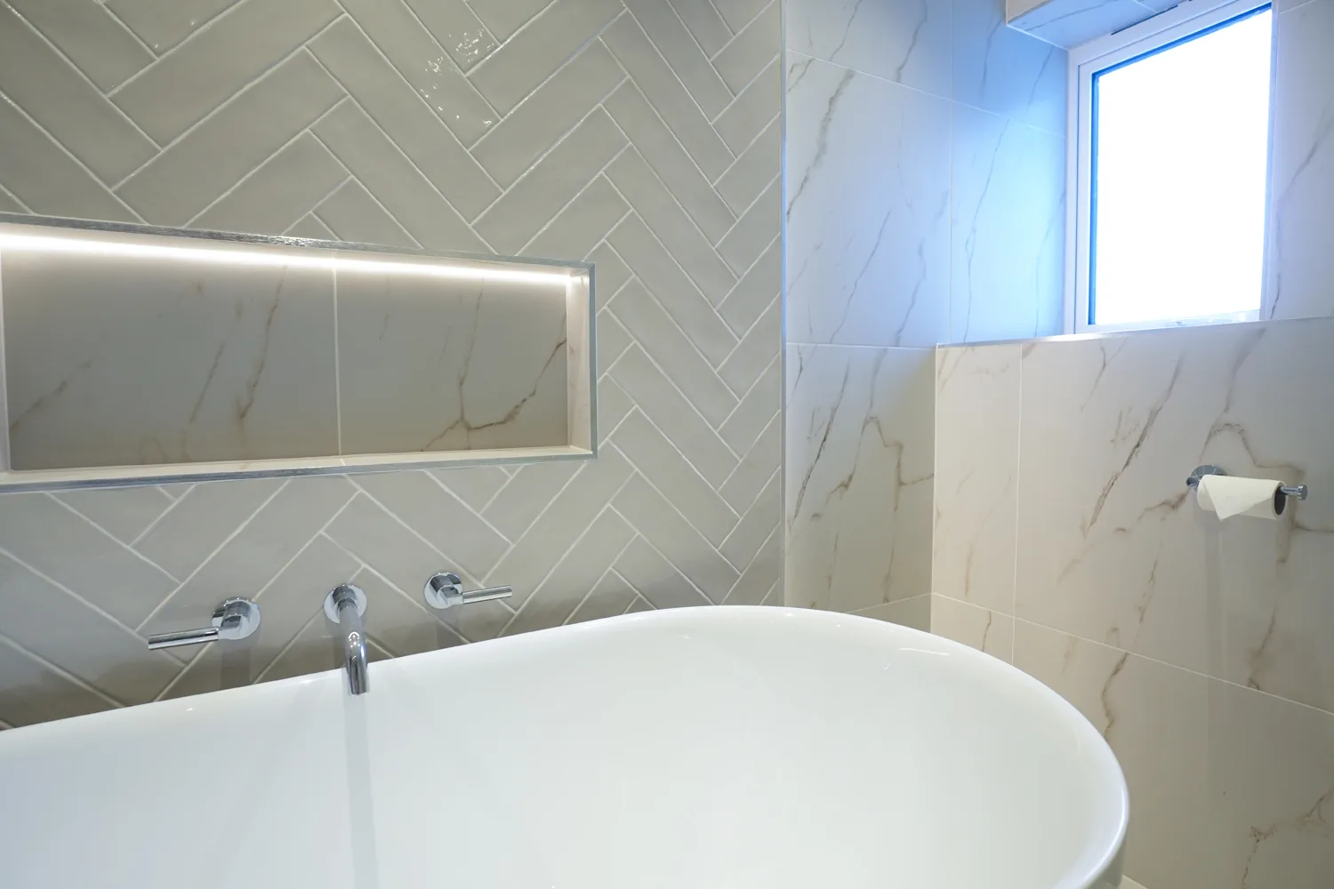 Freestanding bath with wall mounted taps and a lit niche in the Brentwood main bathroom