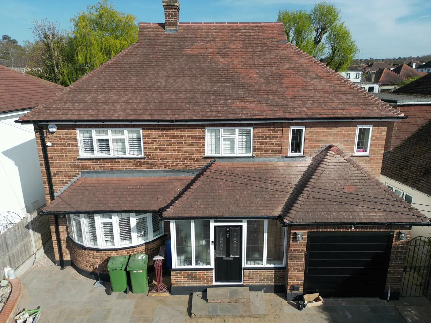 Front elevation of the extended Brentwood house from the air, with its redesigned roof and new first floor