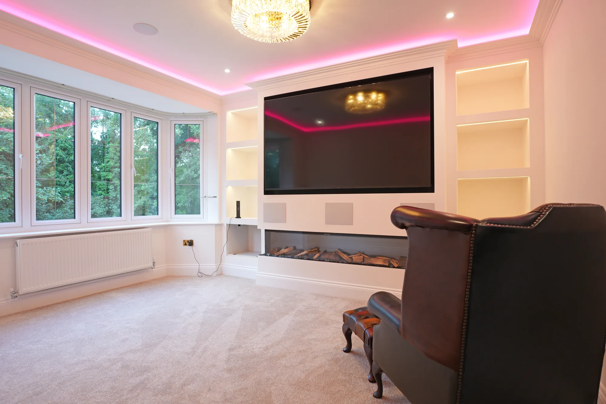 Cinema room at the Chigwell new build with LED feature lighting and fireplace