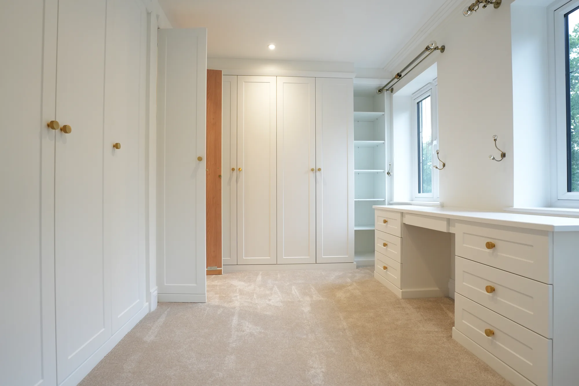 Fitted dressing room with wardrobes and dressing table at the Chigwell project