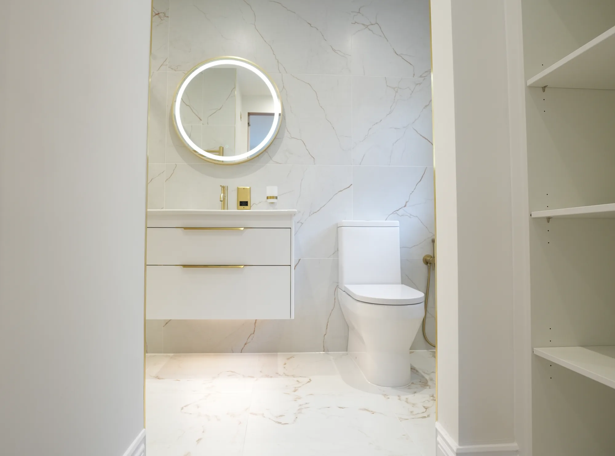 Marble en suite with backlit round mirror at the Chigwell new build.