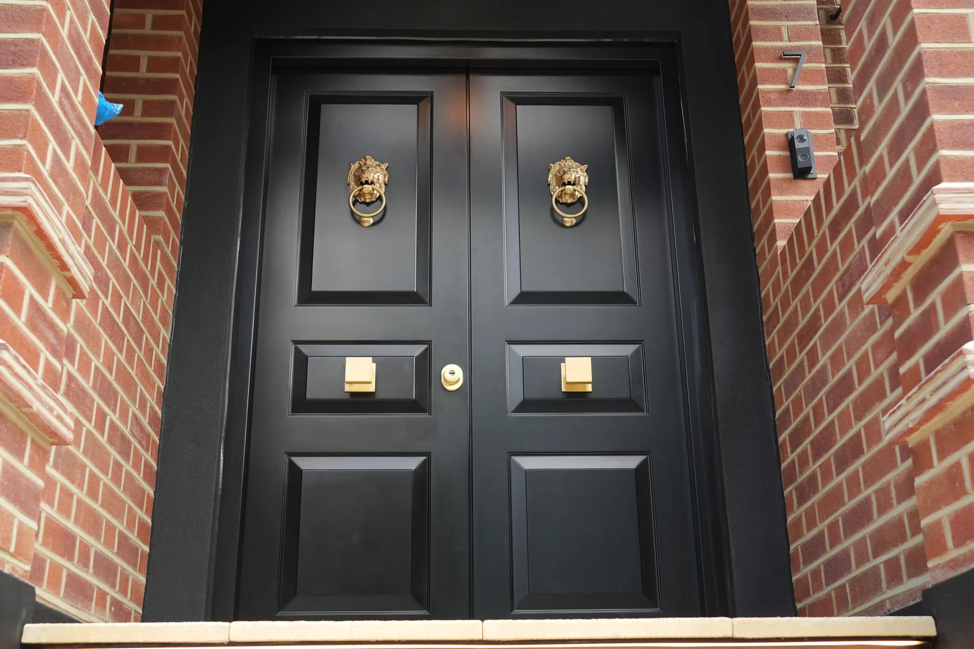 Black double front door with brass lion knockers at the Chigwell new build.
