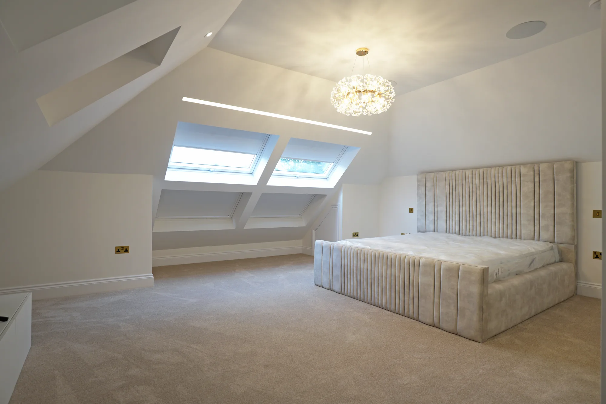 Loft bedroom at Chigwell with skylights and crystal chandelier
