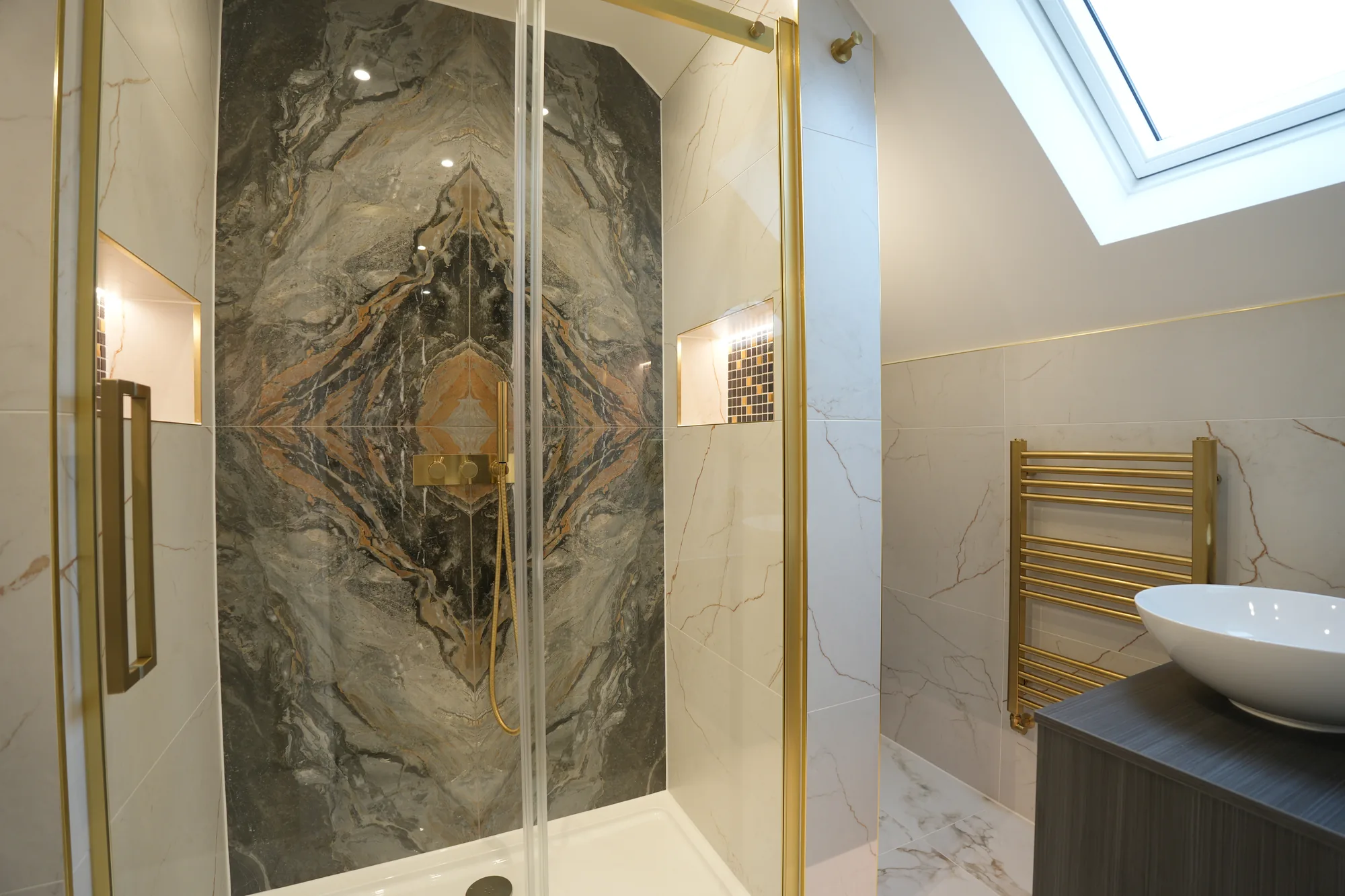 Bookmatched marble feature shower in a loft en suite at the Chigwell project