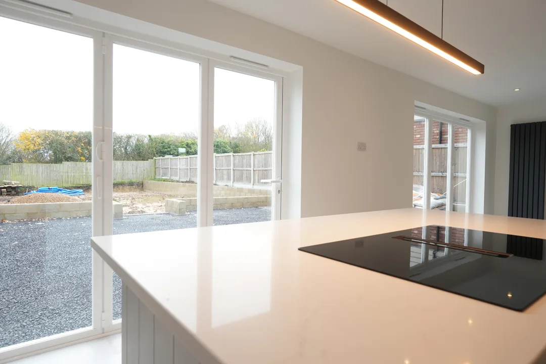 Kitchen island at the Cold Norton house looking out to the garden through the new sliding doors.
