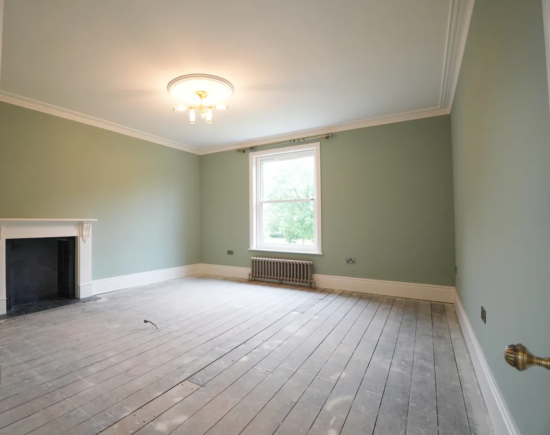 Renovated room at the 1850s Wickham Bishops house with original fireplace and sash window.