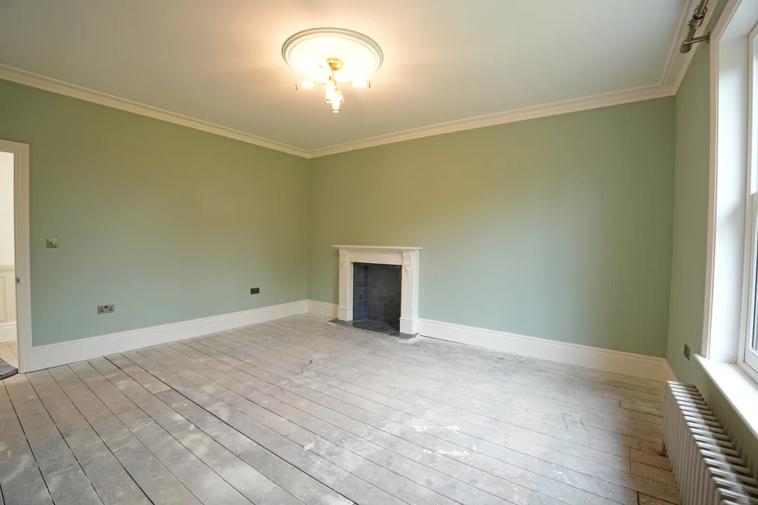 Green painted bedroom with white fireplace surround at the 1850s Wickham Bishops house.