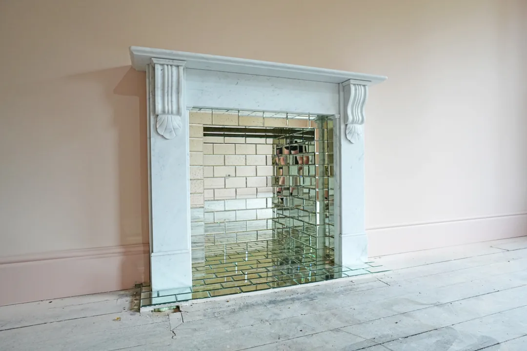 Marble fireplace with mirrored brick inset at the Wickham Bishops renovation.