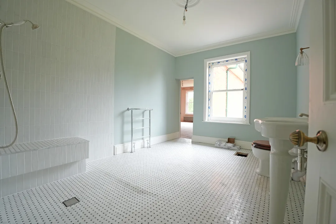 Traditional style bathroom at the Wickham Bishops house with mosaic floor and period sanitaryware.
