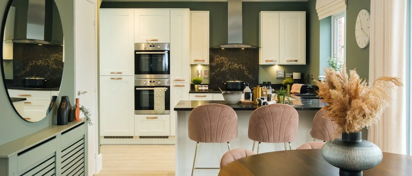 Finished show home kitchen with cream cabinetry and breakfast bar at Hazel Park, Stevenage