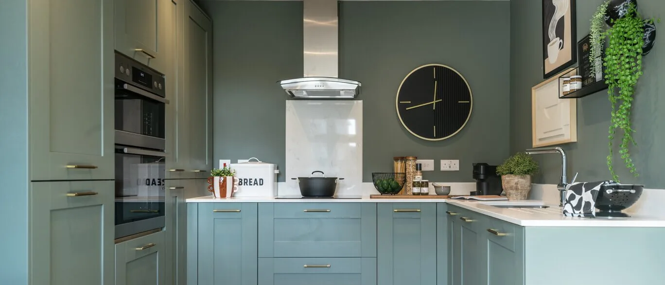 Finished show home kitchen with sage green units at The Foxgloves, Silver End