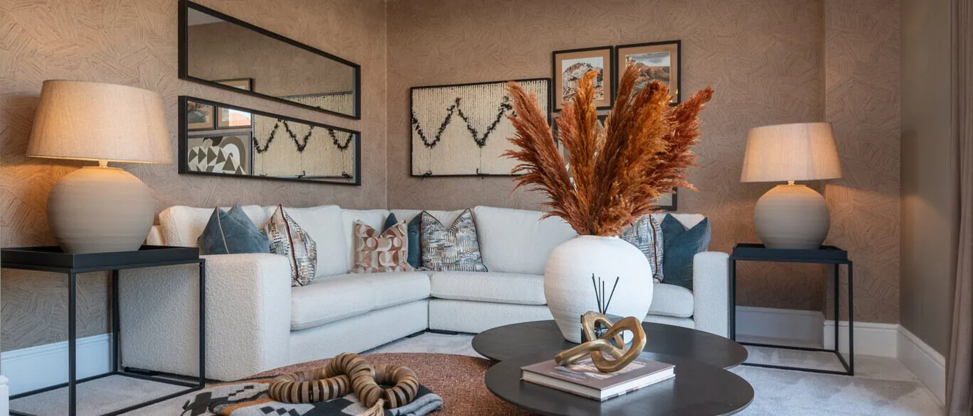 Finished show home lounge with corner sofa and table lamps at The Foxgloves, Silver End