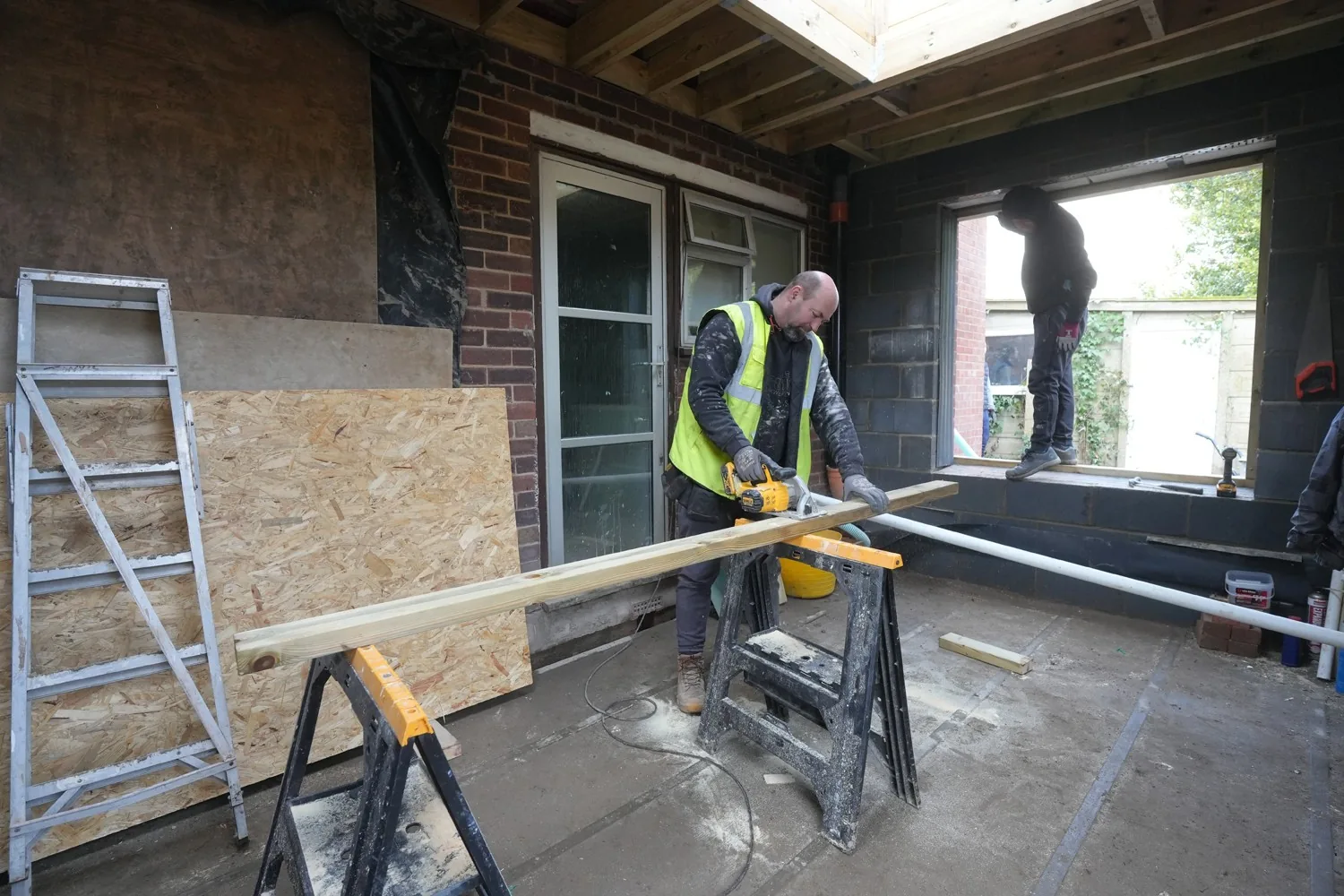 First fix carpentry underway inside the Billericay extension, with timber being cut on sawhorses in the new rooms.