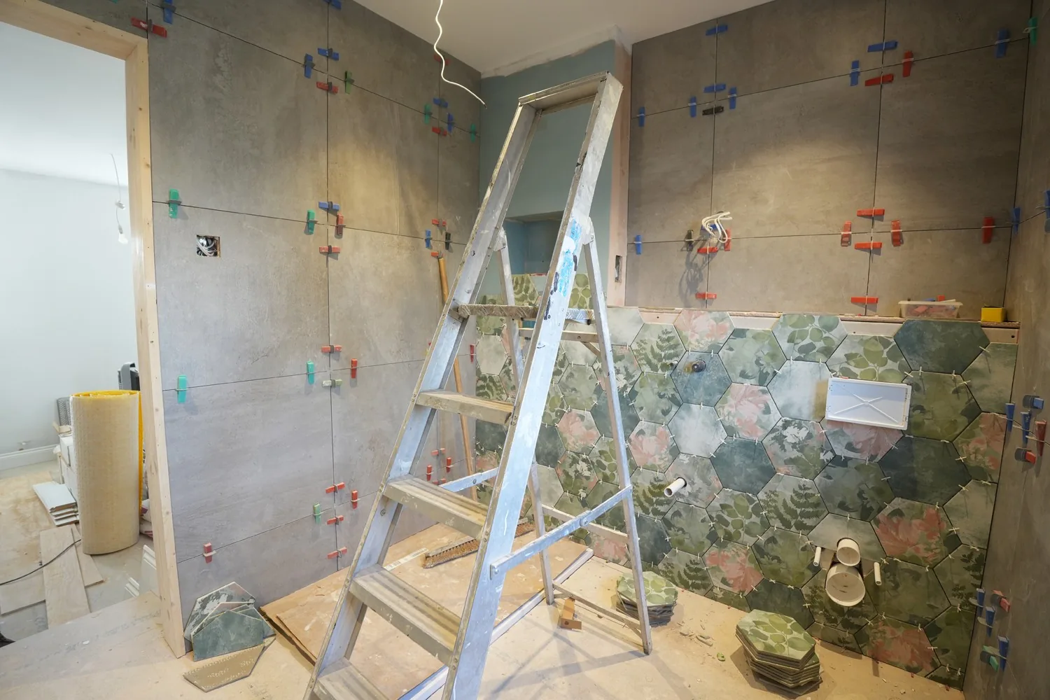 Second view of the Brentwood bathroom mid tiling, the botanical hexagon feature wall meeting the large format grey tiling.
