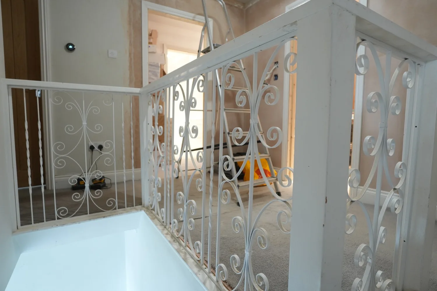 The original wrought iron scrollwork balustrade on the Brentwood landing, kept and freshly repainted during the works.