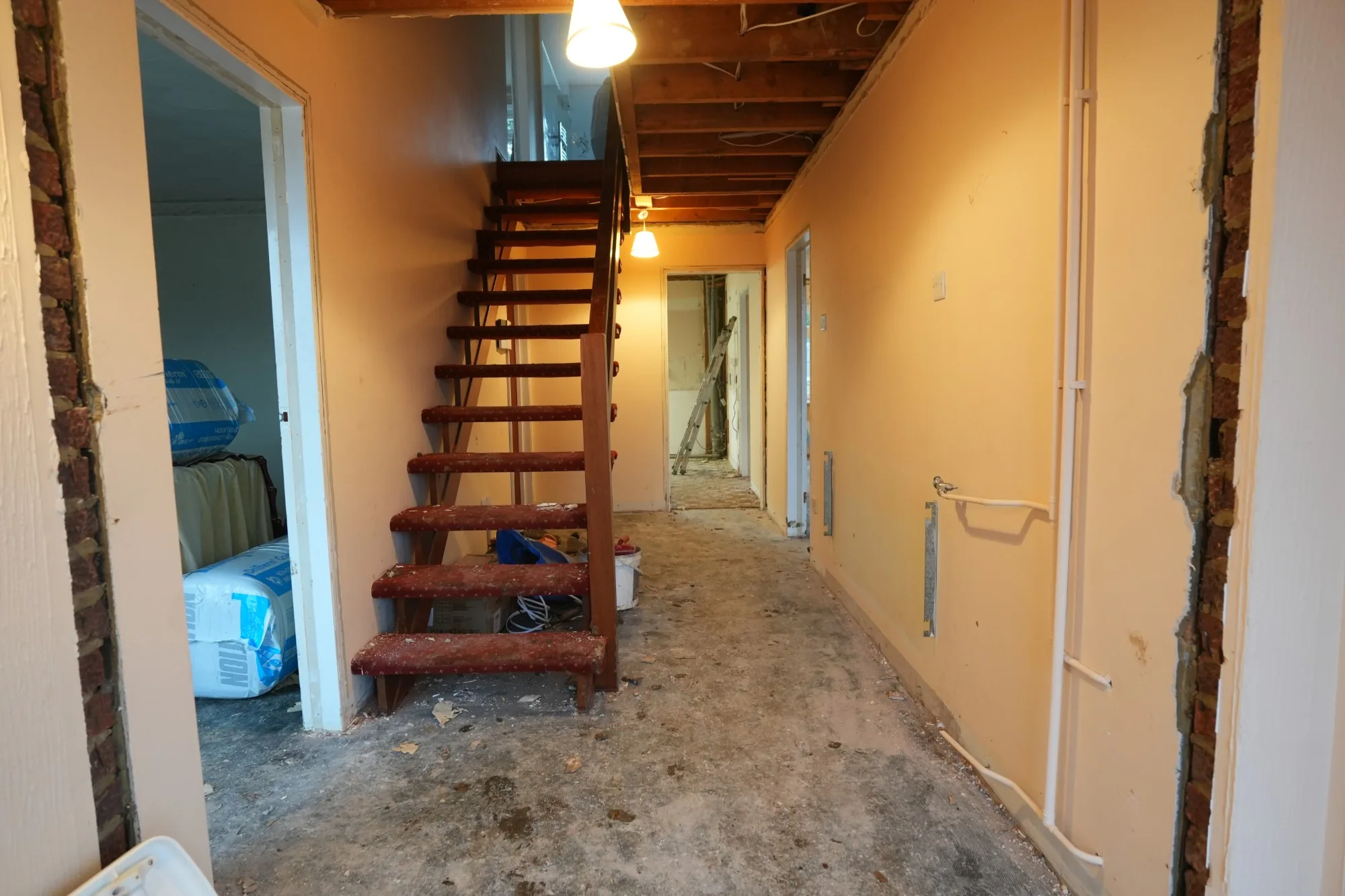 The Cold Norton hallway and landing with the old staircase, carpets already lifted to the bare floor.