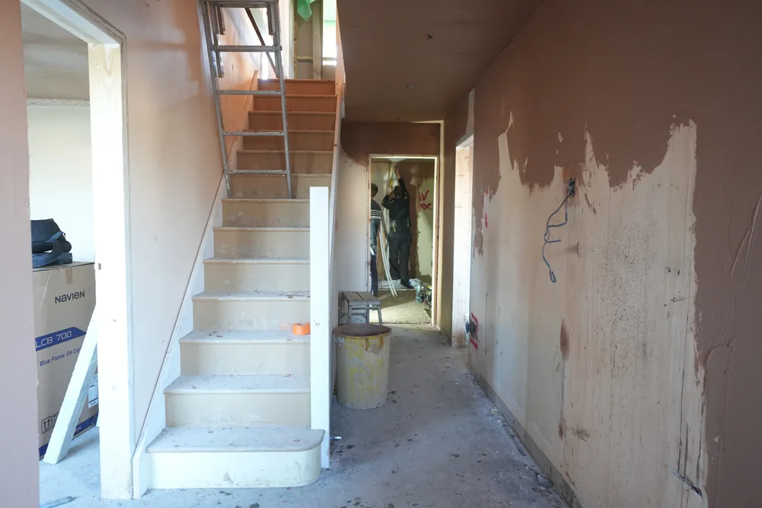 The new staircase in place at Cold Norton, primed and ready for finishing, with the team at work in the room beyond.