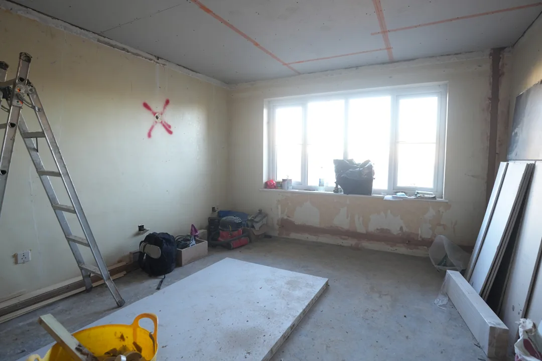 A reboarded ceiling in a Cold Norton bedroom, walls stripped back and boards stacked ready for plastering.