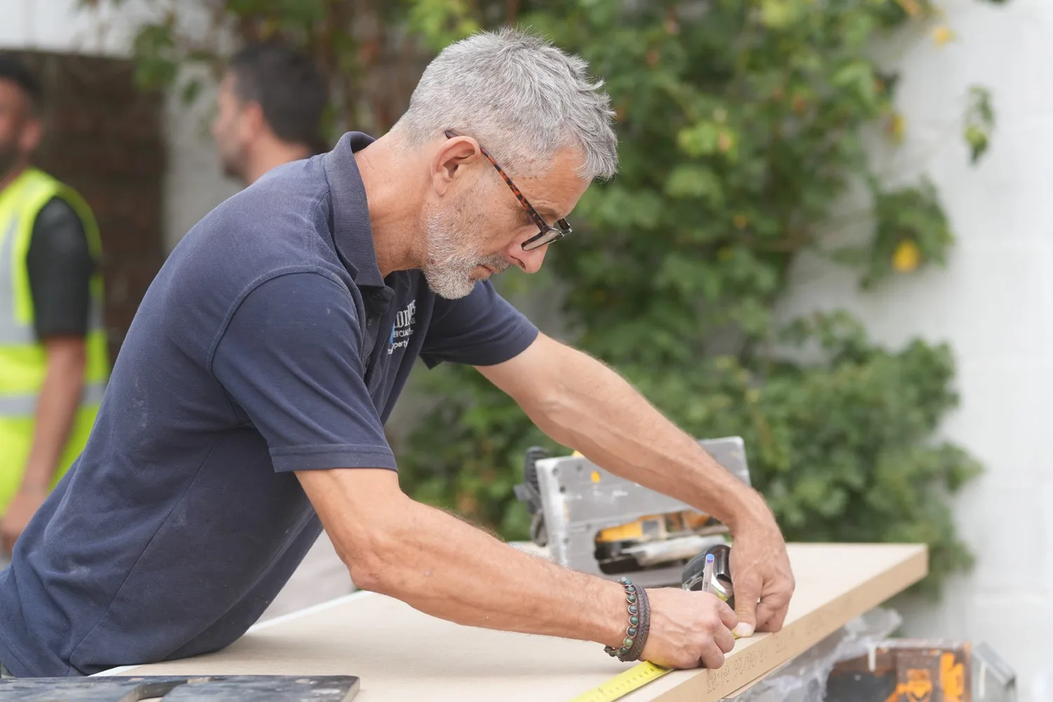 A Madisons operative measuring and marking a board on the saw bench during works at Heathcote Prep School, Danbury.