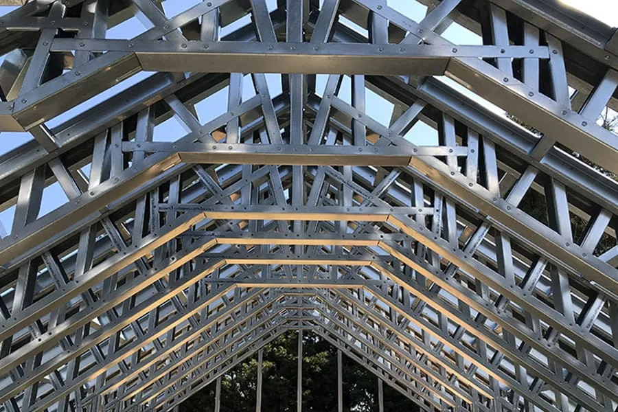 Cold formed steel frame of a new building, gable and roof trusses open to the sky before insulation and cladding.
