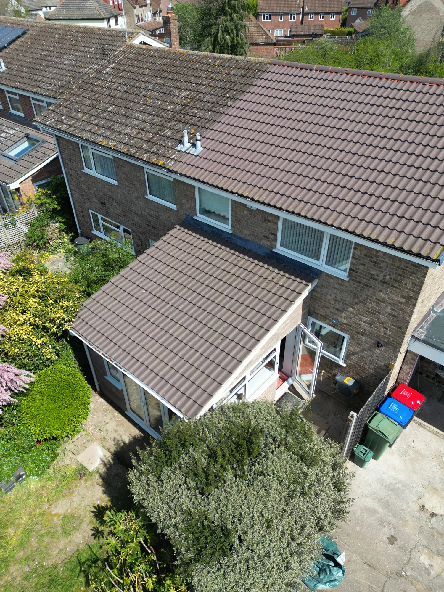 Drone view from above the garden of the Witham extension roof meeting the house, with the side door beyond.