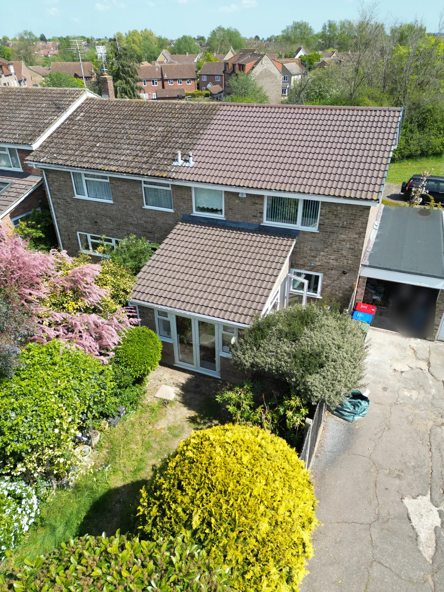 A higher drone view of the Witham house, its rear extension and the garden planting.