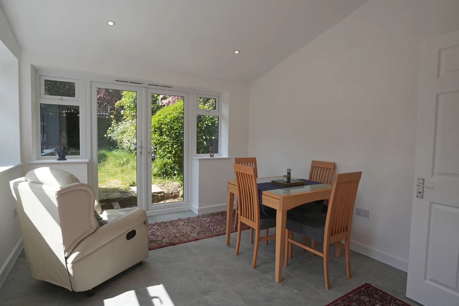 The vaulted single storey extension in Witham, with dining table, French doors and side windows to the garden.